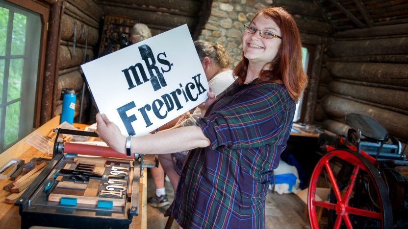 Bread Loaf School of English student holding up sign made in printing cabin.