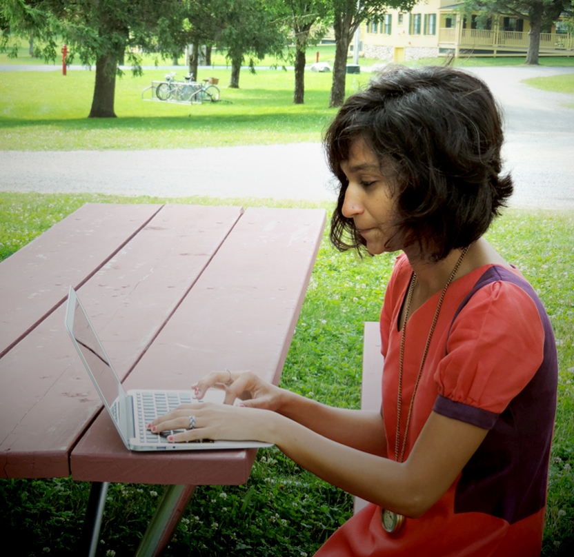 Bread Loaf student works outside at one of the many picnic tables around campus.