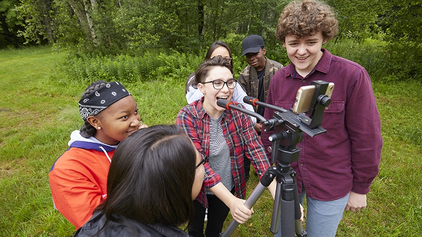 Six BLTN students work a camera outside.