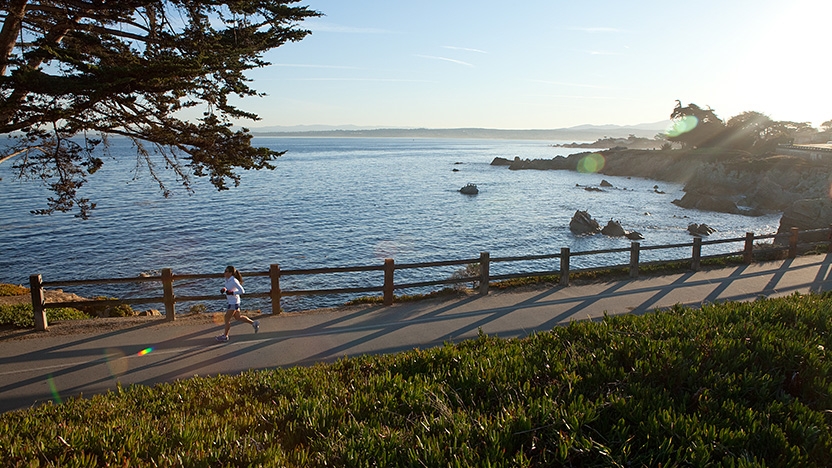 Two runners jog along the shore.