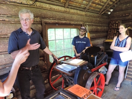 Four BLSE students stand in BL cabin with old letterpress.