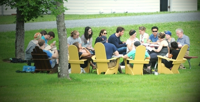 Michael Armstrong hold a class outdoors; students sit in circle for discussion