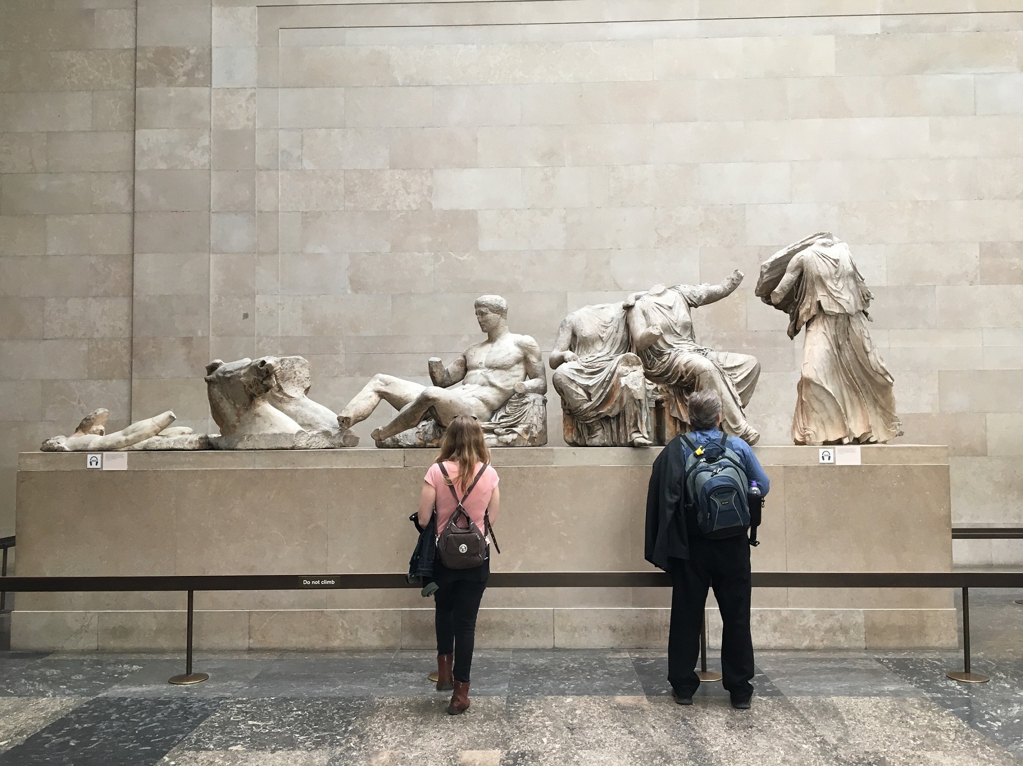 Two people look at statues in the British Museum