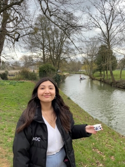 A student smiling next to a canal