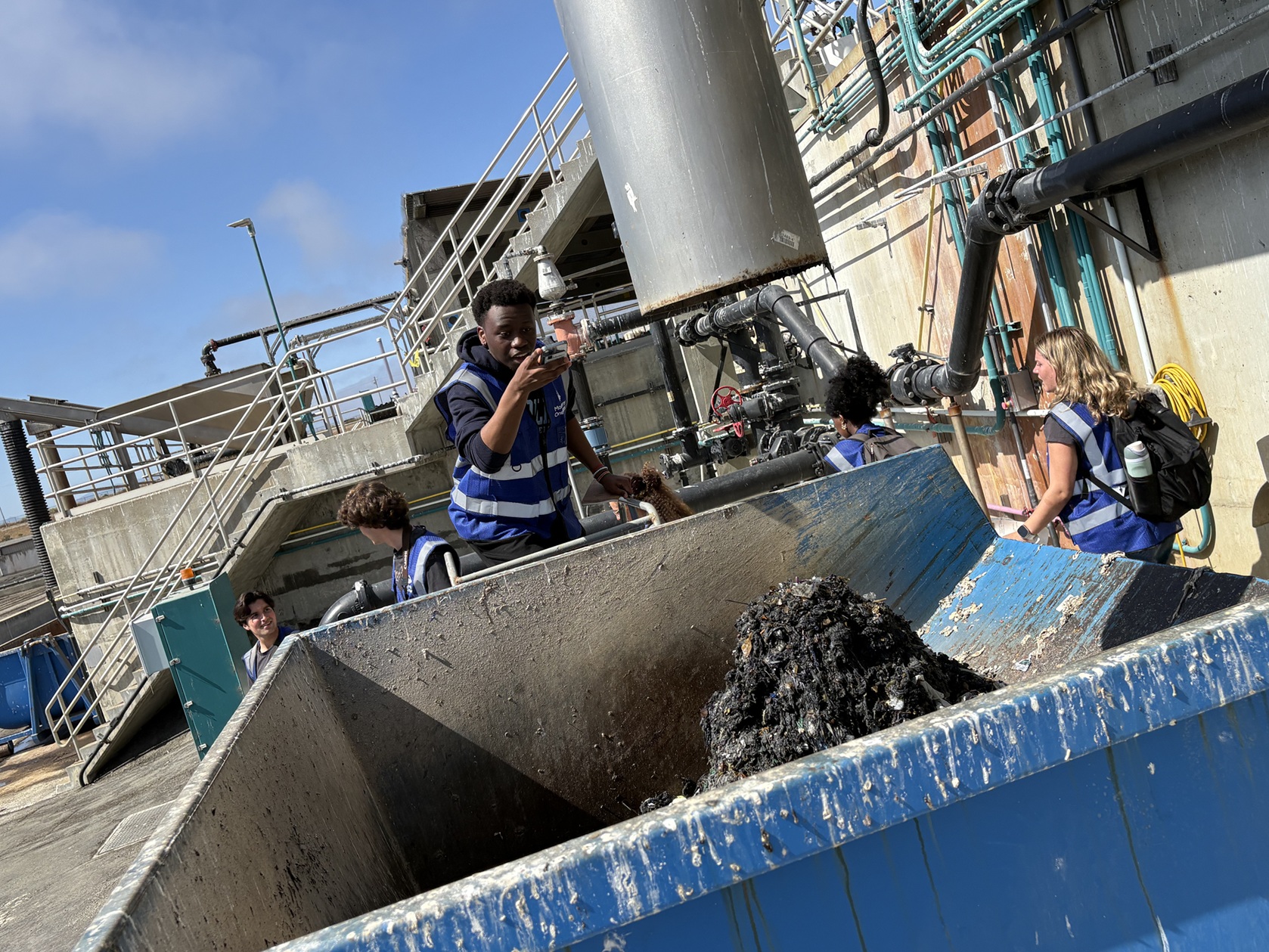 A student takes a photo in a dumpster of waste