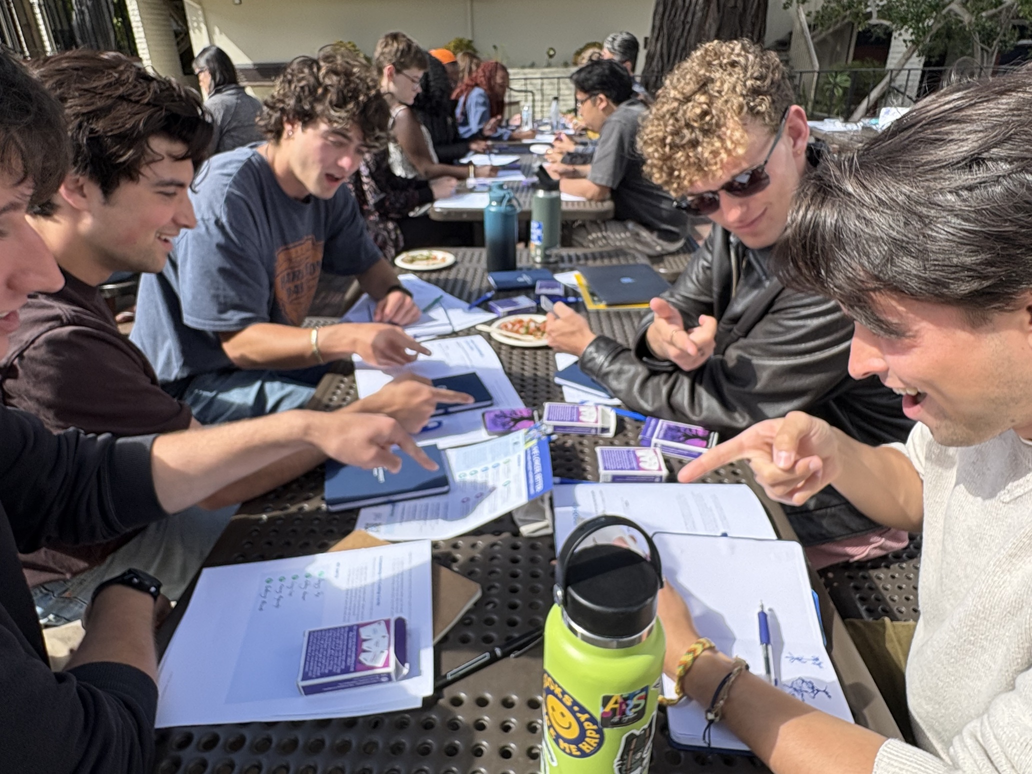 Students play a game with cards, pointing at each other