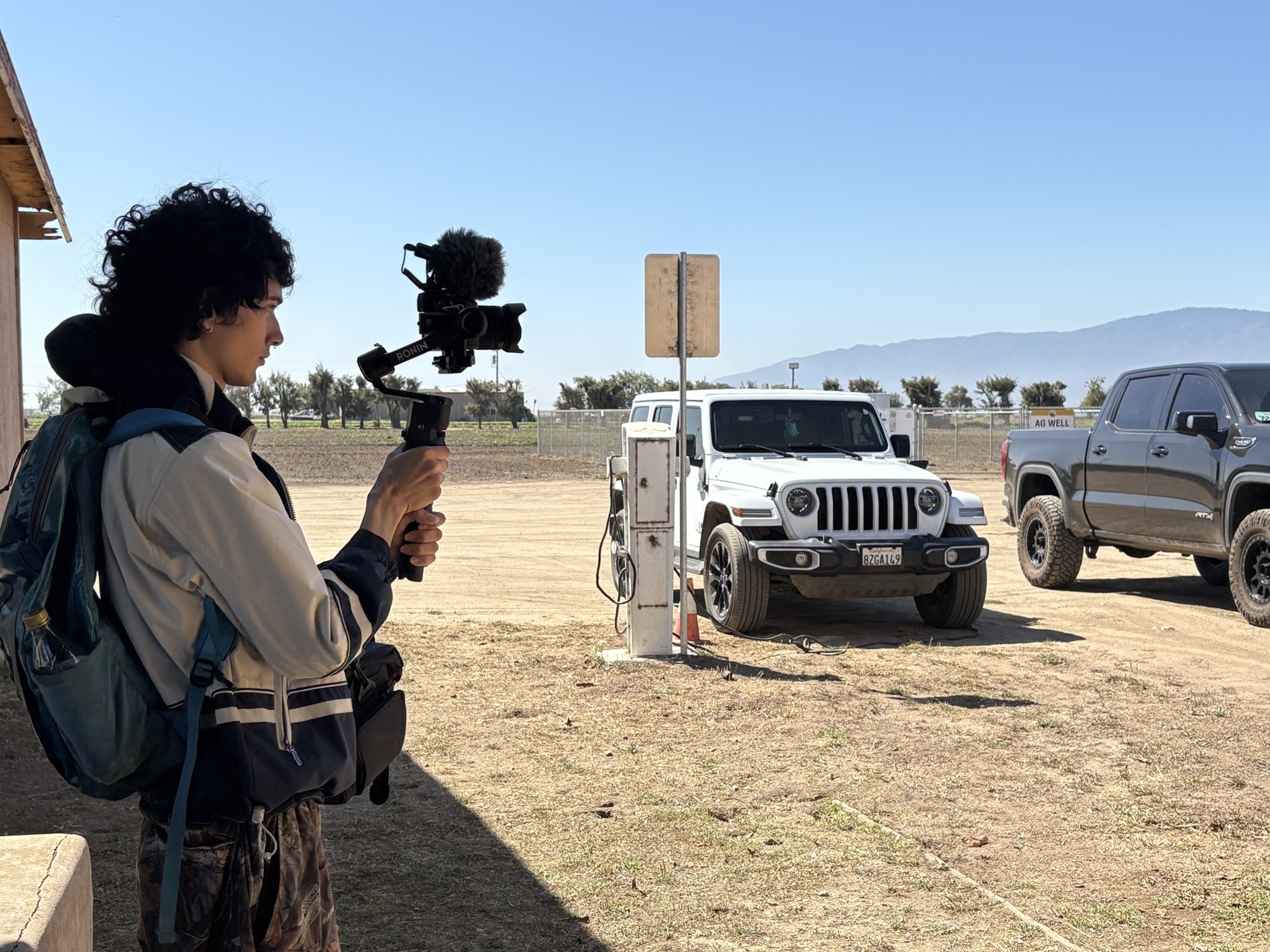 A student stands with a video camera