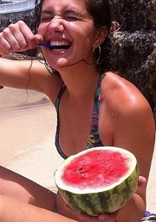 A student eating a watermelon with a spoon