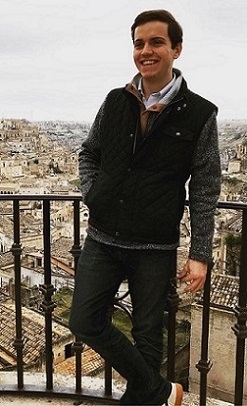 A student stands above an old city