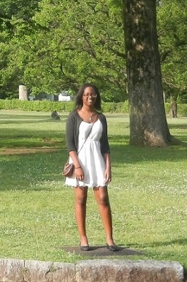 A student stands in a grassy field