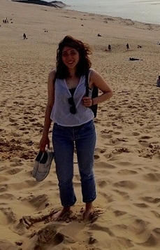 A student stands on the beach