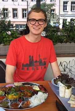 A student at a table with Indian food