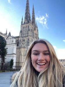 Student smiling in front of a cathedral
