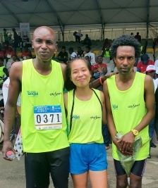 A student smiling with a pair of runners