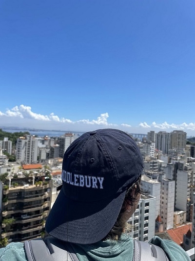 A student facing a cityscape with "Middlebury" on their hat