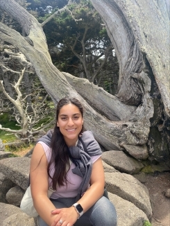 Student smiling in front of a tree