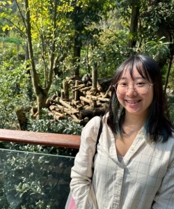 Student smiling with a panda in the background