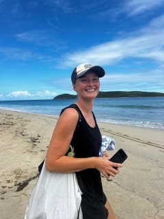Student in a basecall cap smiling on the beach