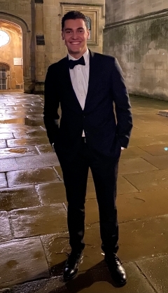 Student smiling in a black suit and bow tie