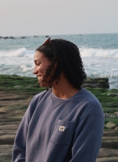 Student smiling in profile by the sea