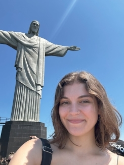 Student smiling in front of a sculpture