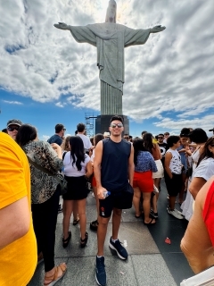 Student posing in front of a sculpture