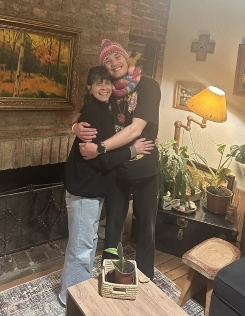 Student in a hat embracing their host mother