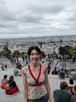 Student smiling in front of a grey city view