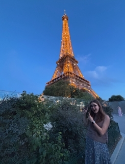 Student posing in front of the Eiffel tower at night