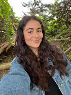 Student in a jean jacket smiling for a selfie