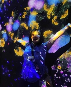Student smiling behind a colorful projection