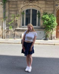 Student posing in front of a French building facade
