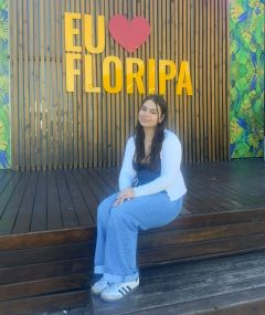 Student posing in front of a bright sign
