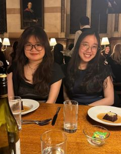 Two students smiling at a dinner table