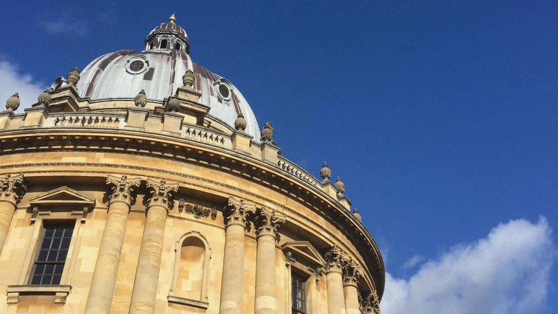 The Radcliffe Camera library in Oxford on a sunny day. The blue sky highlights the golden colour of the stone.