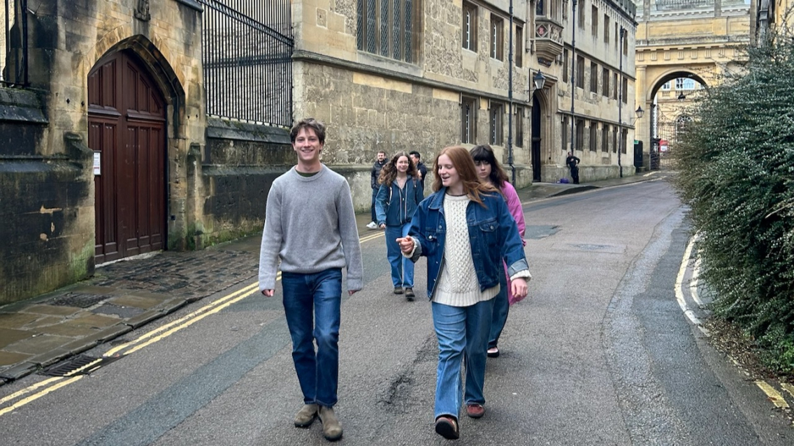 Students walk through an Oxford street on their way to Merton College for a private tour of the library and chapel.