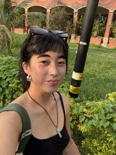 Student posing in front of a brick building