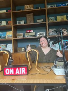 Student posing at a radio desk