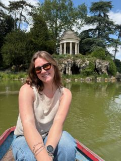 Student smiling in front of green water