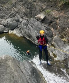 Student rappelling down a waterfall