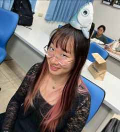 Student posing with a fish on their head