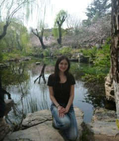 Student posing in front of a reflective pond