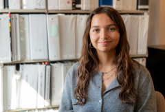 Student smiling in front of archives