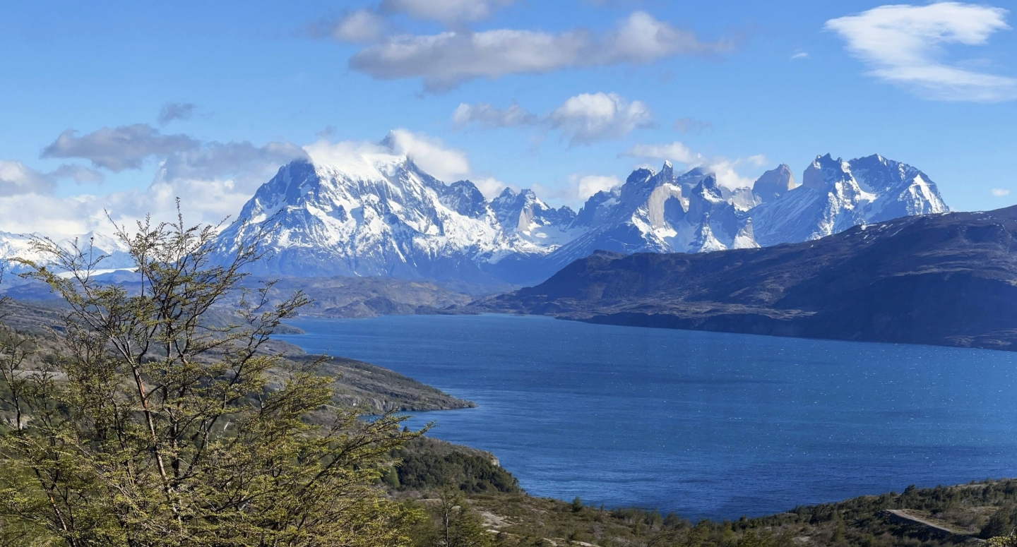 Blue water with snow capped mountains in the background
