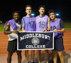Students holding a "Middlebury" banner with running jerseys on