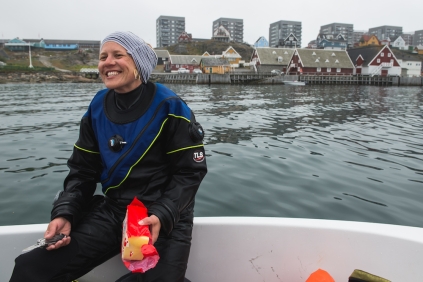 A woman smiling on a boat on the water