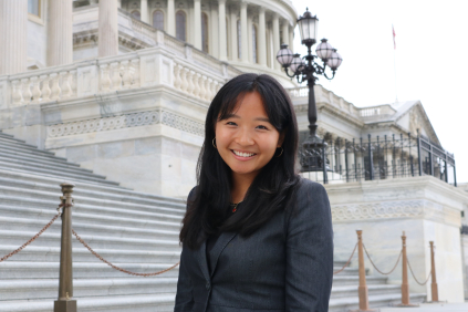 A student smiling in front of a building