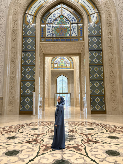 Student in a blue robe at a mosque