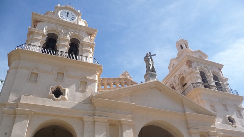 Top of white church with blue sky in background