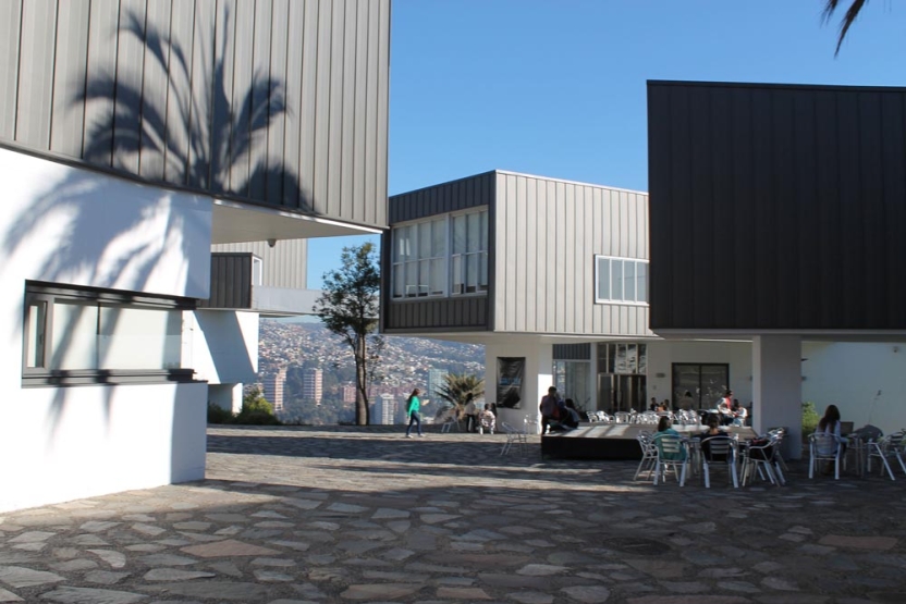 Outdoor center of campus students sitting at tables